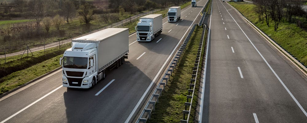 row of long haul trucks on highway