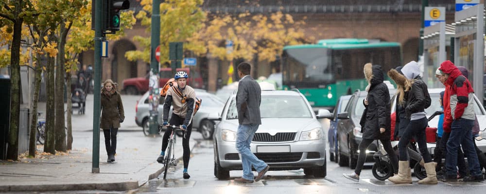 pedestrians, bicycle and vehicles stopped at intersection